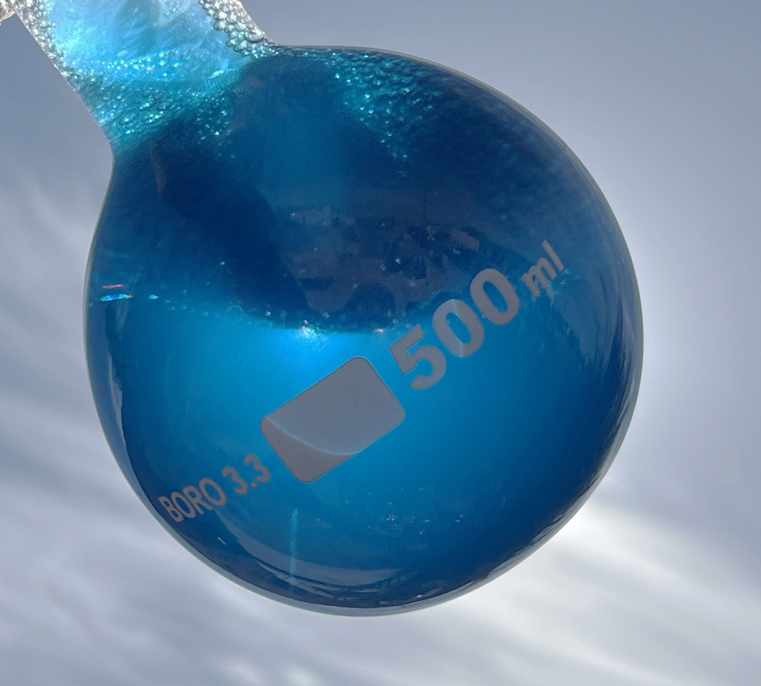 Bright blue phycocyanin extract derived from spirulina in a laboratory flask